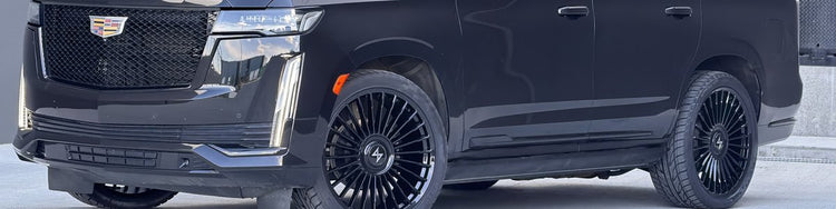 Black 24 inch alloy wheels fitted on a Cadillac Escalade at the First Auto Nation warehouse