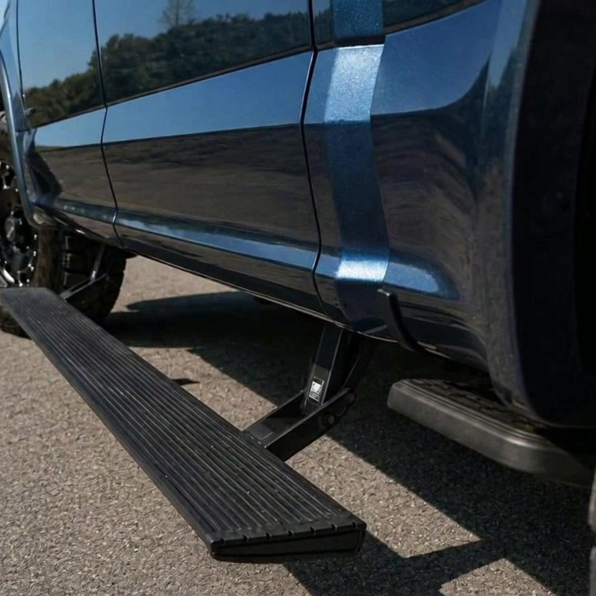 Sentinel electric side steps deployed under a pickup truck door